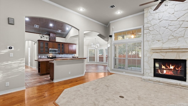 kitchen featuring a center island, dark wood-type flooring, a fireplace, appliances with stainless steel finishes, and tasteful backsplash