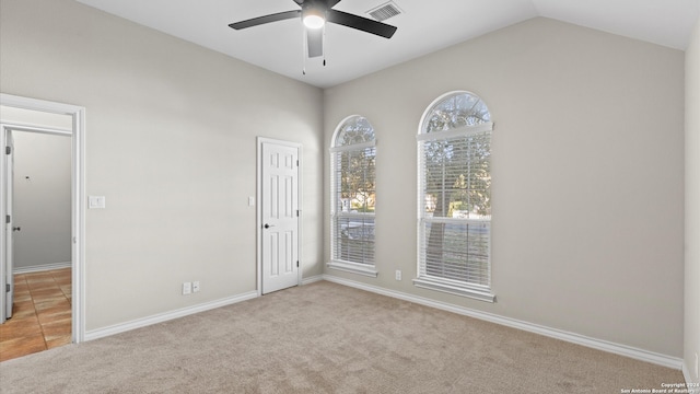 carpeted spare room featuring ceiling fan and lofted ceiling