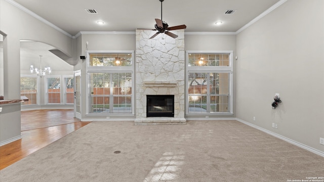 unfurnished living room featuring a stone fireplace, crown molding, ceiling fan with notable chandelier, and hardwood / wood-style flooring