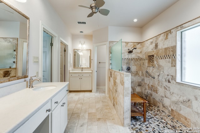 bathroom featuring a tile shower, vanity, and ceiling fan