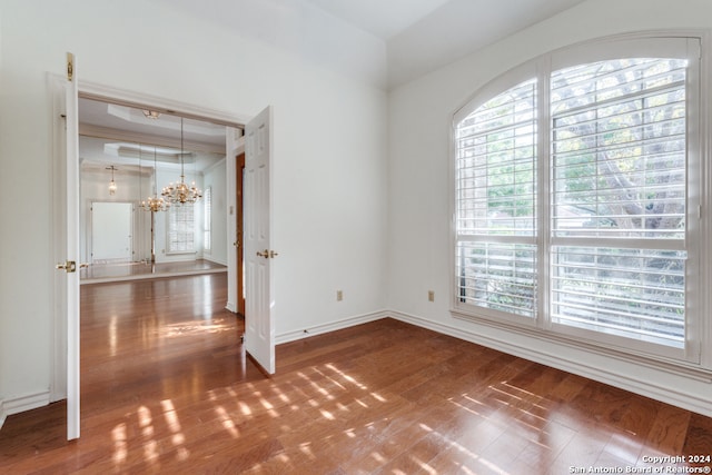 unfurnished room with dark hardwood / wood-style flooring and an inviting chandelier