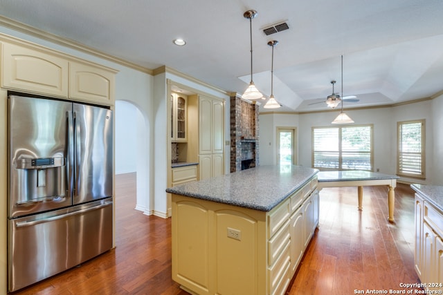 kitchen with hardwood / wood-style floors, stainless steel refrigerator with ice dispenser, a tray ceiling, and cream cabinets