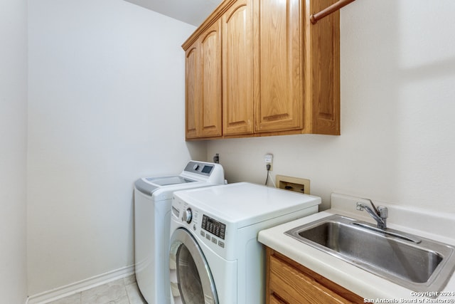 laundry room featuring light tile patterned flooring, cabinets, separate washer and dryer, and sink