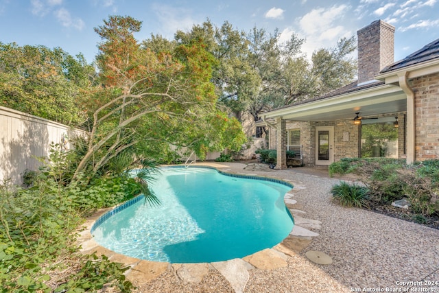 view of swimming pool featuring ceiling fan and a patio area