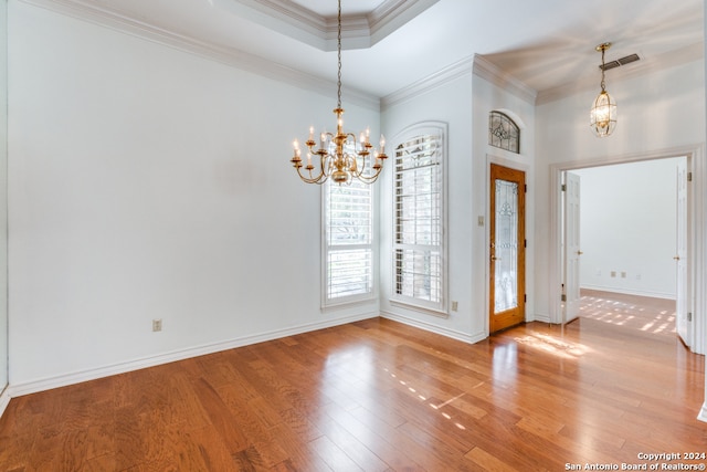 interior space featuring hardwood / wood-style floors, crown molding, and a notable chandelier