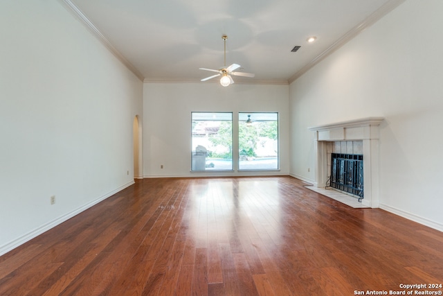 unfurnished living room with a tile fireplace, dark hardwood / wood-style flooring, ceiling fan, and ornamental molding