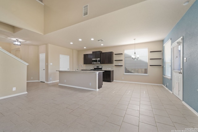 kitchen featuring sink, stainless steel appliances, a chandelier, decorative light fixtures, and a kitchen island with sink