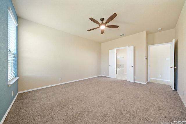 unfurnished bedroom with carpet flooring, multiple windows, and ceiling fan