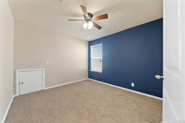 carpeted spare room with ceiling fan