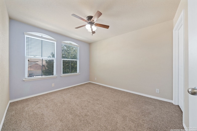 carpeted empty room featuring ceiling fan