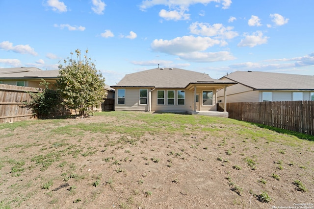 rear view of property with a lawn