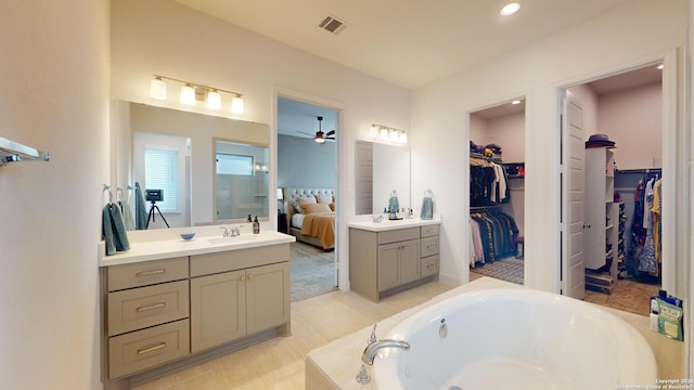 bathroom with a bath, vanity, and ceiling fan