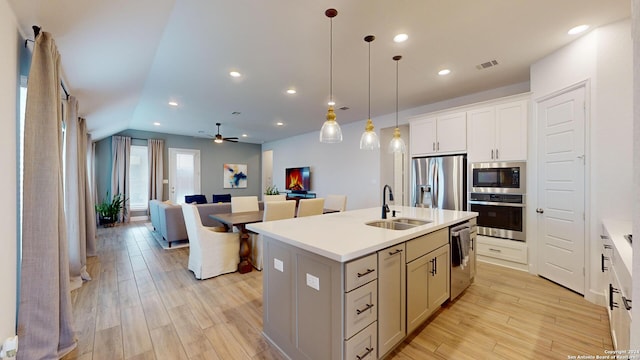 kitchen featuring a kitchen island with sink, light hardwood / wood-style flooring, ceiling fan, and stainless steel appliances