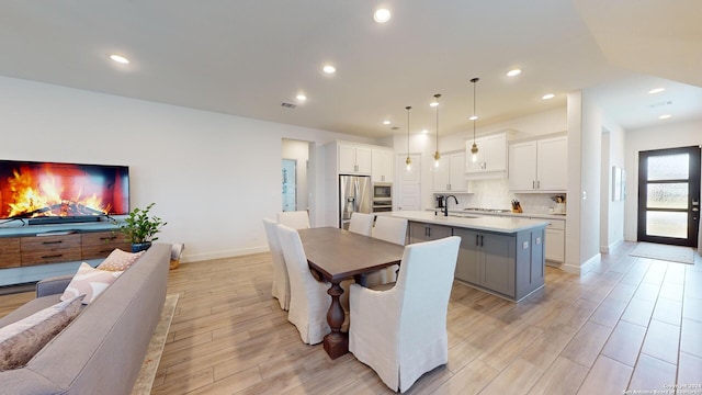 dining area with light hardwood / wood-style flooring and sink