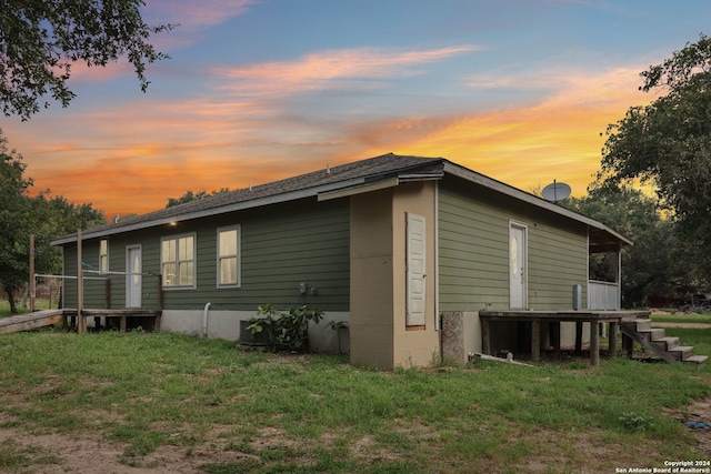 property exterior at dusk featuring a yard