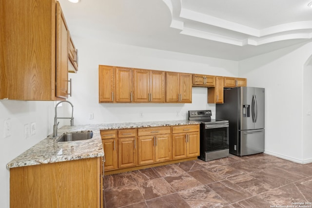 kitchen with light stone countertops, sink, and appliances with stainless steel finishes