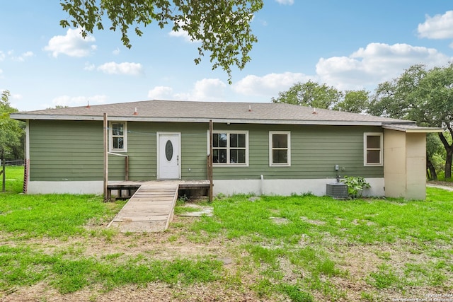 back of property featuring a lawn and central air condition unit