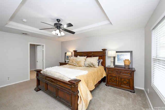 bedroom with a raised ceiling, ceiling fan, crown molding, and light colored carpet