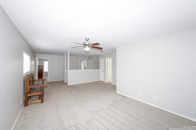 unfurnished living room featuring ceiling fan and light carpet