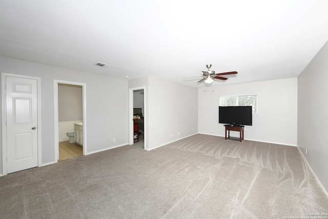 unfurnished living room featuring light colored carpet and ceiling fan