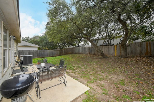 view of yard featuring central air condition unit and a patio