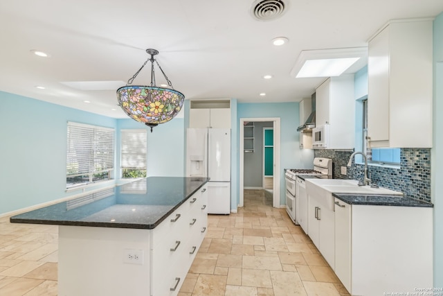 kitchen featuring a kitchen island, pendant lighting, white appliances, decorative backsplash, and white cabinets