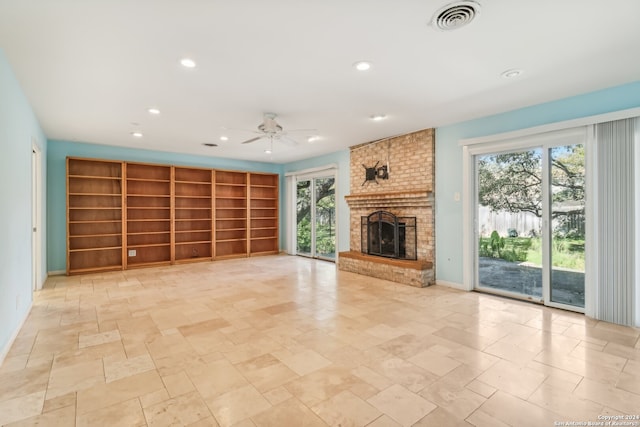 unfurnished living room featuring a fireplace, ceiling fan, and plenty of natural light