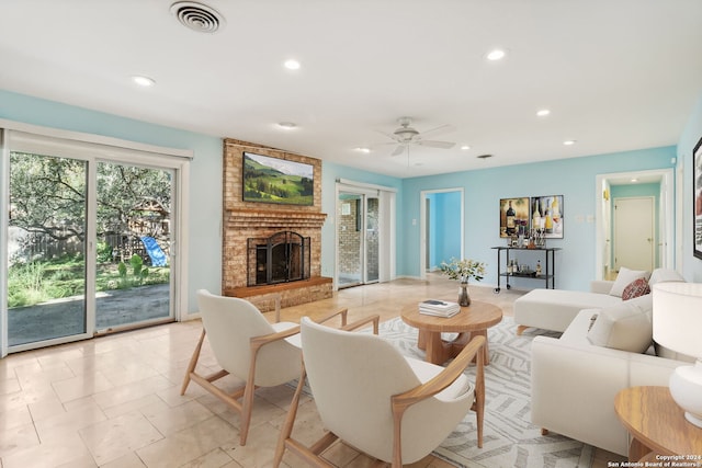 living room with ceiling fan and a brick fireplace