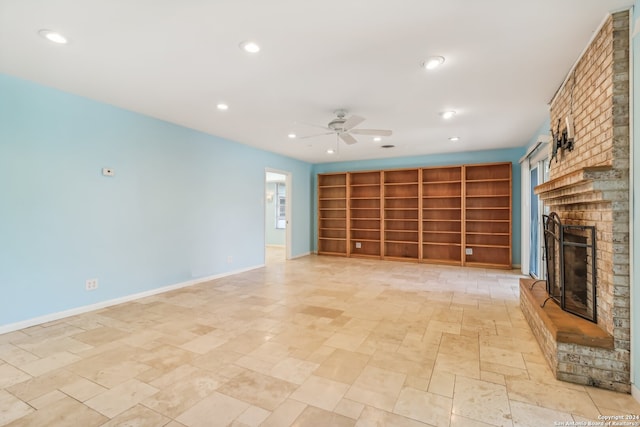 unfurnished living room with a brick fireplace and ceiling fan