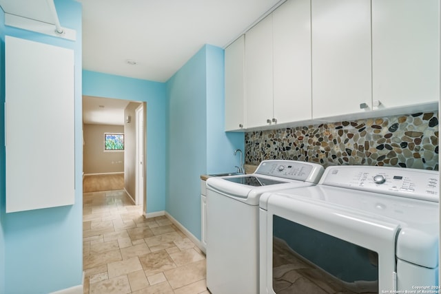 laundry room featuring cabinets, washing machine and dryer, and sink