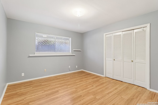 unfurnished bedroom featuring light hardwood / wood-style floors and a closet