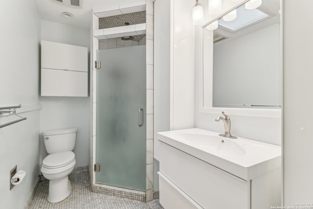 bathroom featuring tile patterned flooring, vanity, a shower with shower door, and toilet