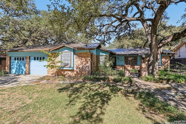 ranch-style house featuring a front yard and a garage