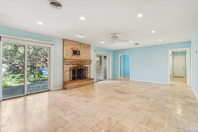 unfurnished living room with ceiling fan, a healthy amount of sunlight, and a brick fireplace