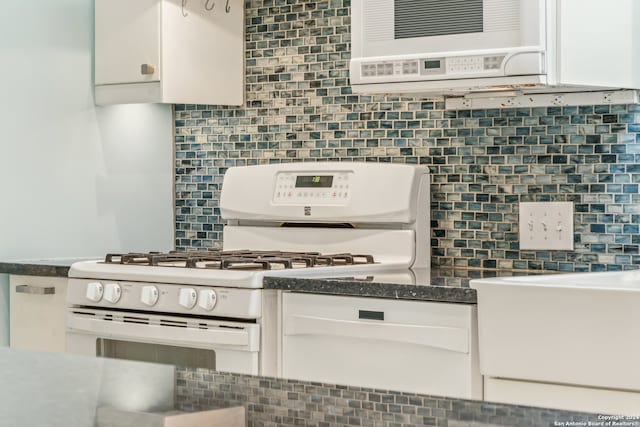 kitchen with white cabinets, backsplash, and white range with gas cooktop