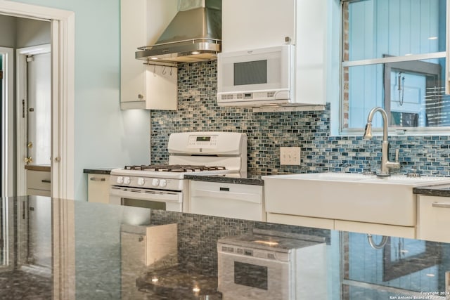 kitchen featuring white cabinets, sink, wall chimney exhaust hood, and white appliances