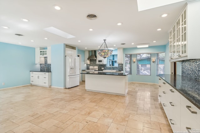 kitchen featuring white cabinets, white appliances, and wall chimney range hood