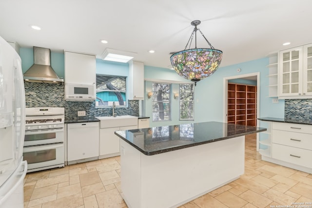 kitchen featuring pendant lighting, a center island, white appliances, white cabinets, and wall chimney exhaust hood