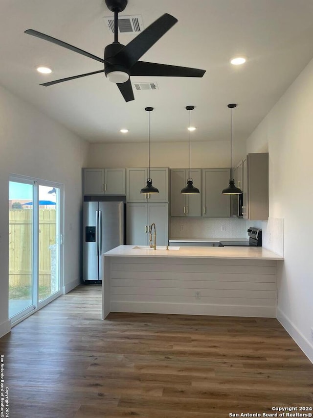 kitchen with kitchen peninsula, dark hardwood / wood-style flooring, stainless steel appliances, and sink