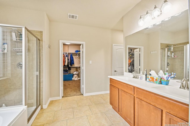 bathroom featuring tile patterned flooring, shower with separate bathtub, and vanity