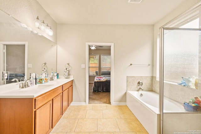 bathroom featuring tile patterned floors, a bathtub, ceiling fan, and vanity