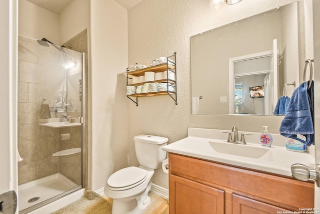 bathroom featuring toilet, vanity, and walk in shower