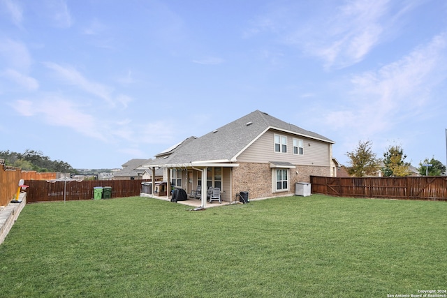 rear view of property featuring a yard and a patio