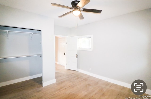 unfurnished bedroom with a closet, hardwood / wood-style flooring, and ceiling fan