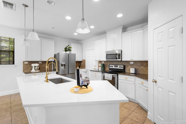 kitchen featuring white cabinetry, a kitchen island with sink, stainless steel appliances, and decorative light fixtures