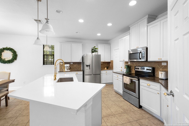 kitchen with white cabinets, appliances with stainless steel finishes, decorative light fixtures, and sink