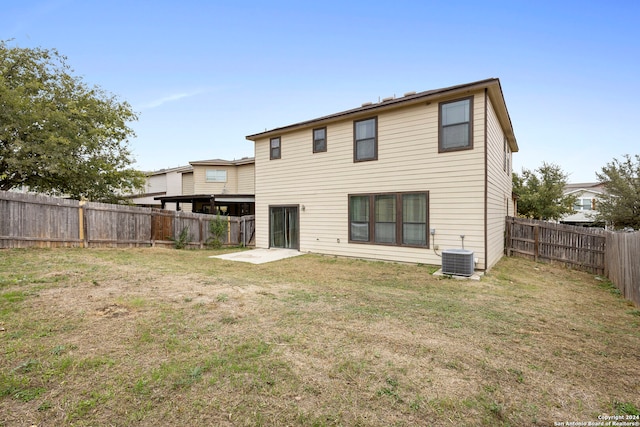 rear view of house with a lawn and central air condition unit