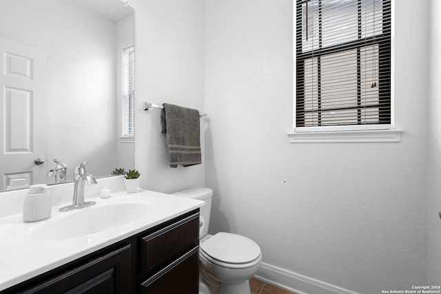 bathroom with tile patterned flooring, vanity, and toilet