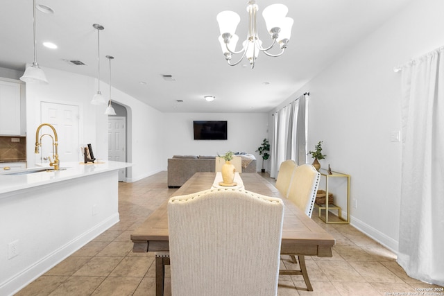 tiled dining room featuring a notable chandelier and sink