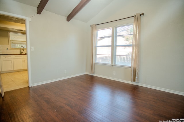 unfurnished room with lofted ceiling with beams, light hardwood / wood-style floors, and sink